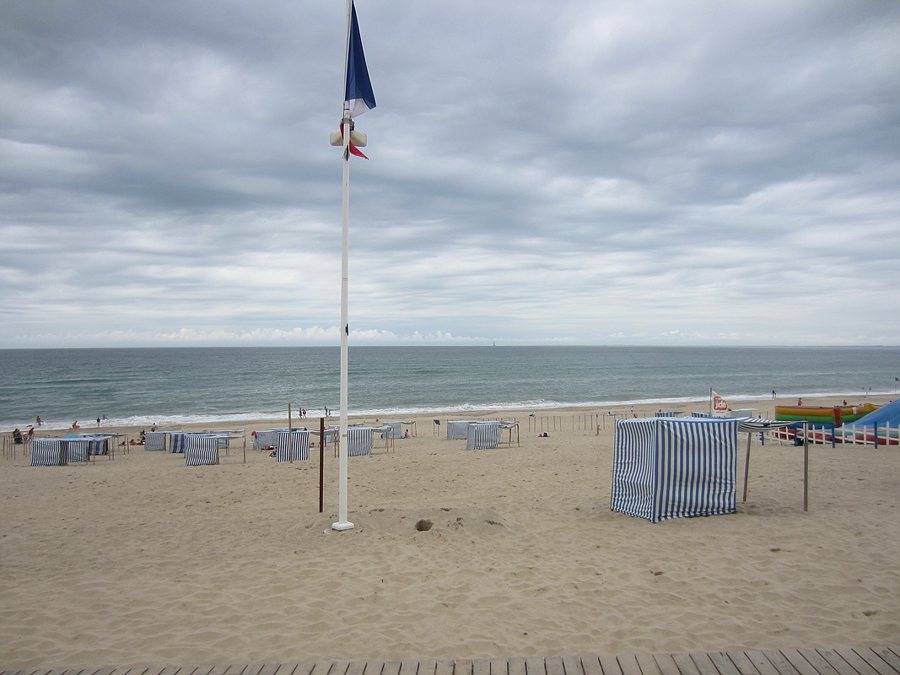 Sandstrand mit blau-weiß gestreiften Strandhütten in Soulac-sur-Mer